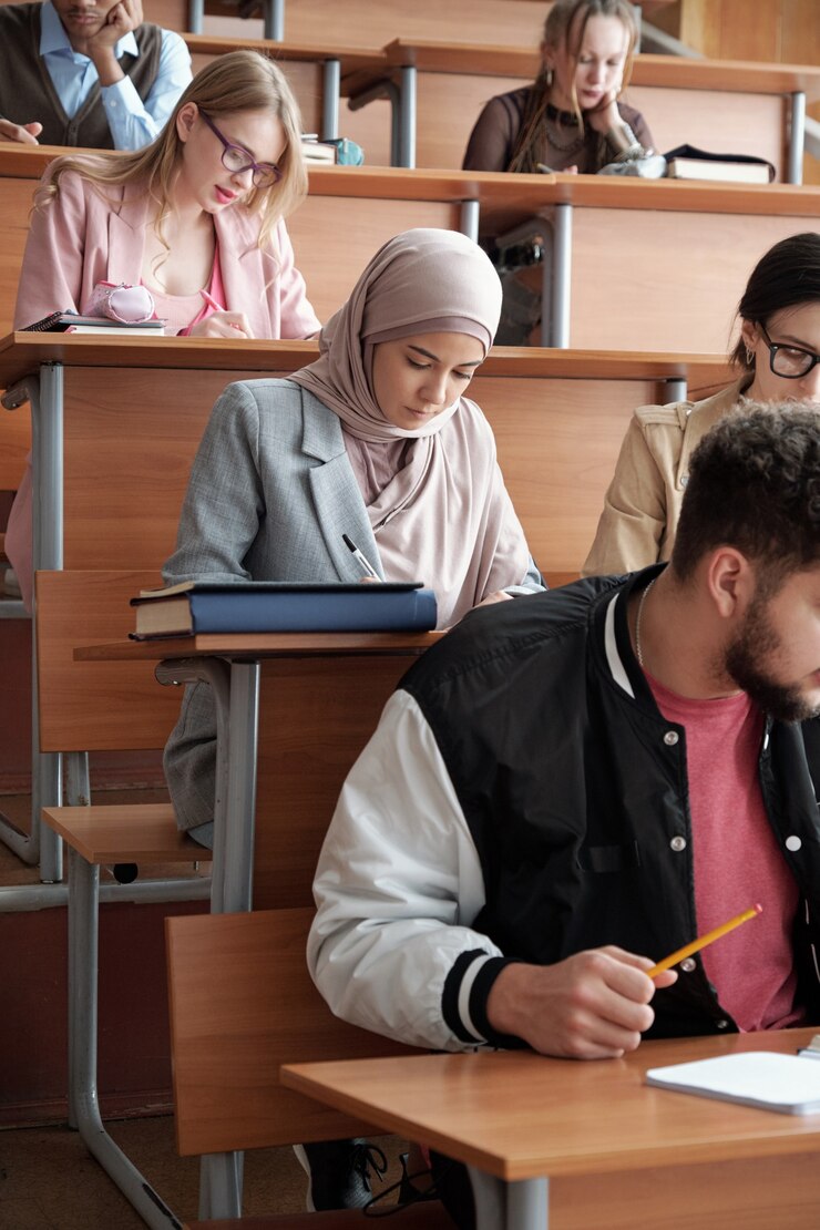 Étudiants prenant des notes tout en travaillant individuellement en classe