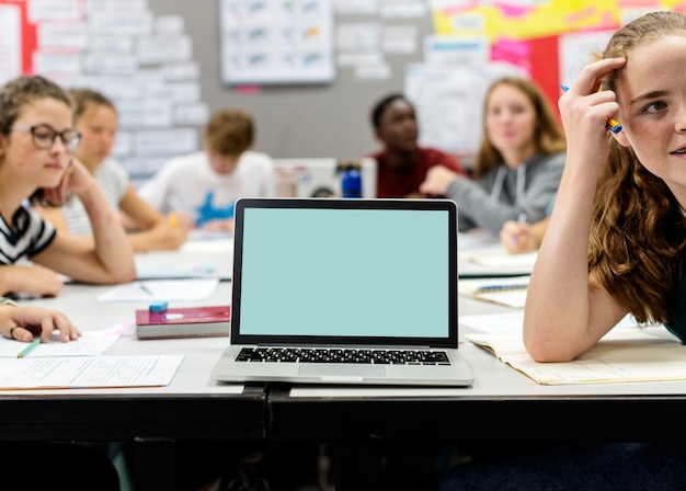 Les étudiants qui étudient dans une salle de classe avec un ordinateur portable à écran blanc