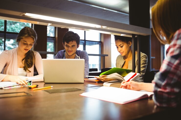 Photo étudiants réfléchis travaillant ensemble au bureau en utilisant un ordinateur portable