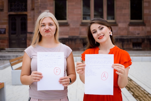 Les étudiants avec des résultats de test debout près de l'université