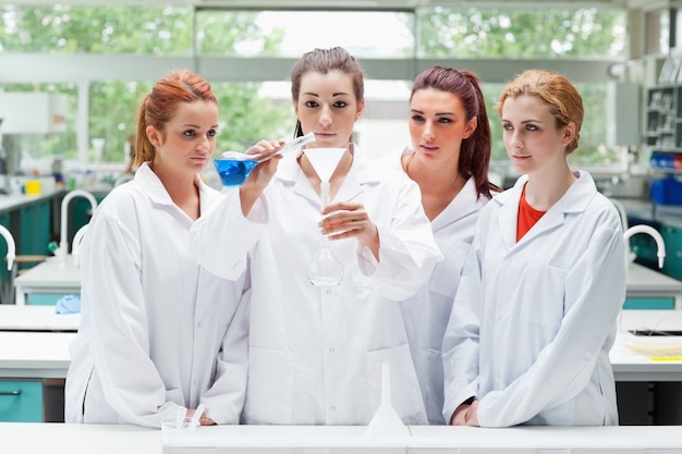 Étudiants de science verser le liquide dans une fiole