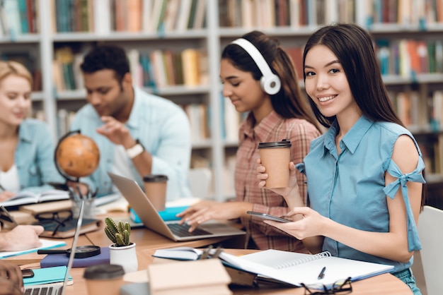 Les étudiants sont assis à table dans la bibliothèque.