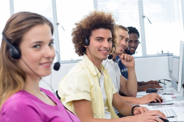 Photo Étudiants souriants utilisant des casques d'écoute en classe d'informatique