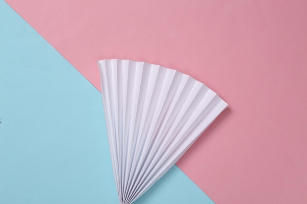 Photo Éventail en papier sur fond pastel bleu rose concept art minimalisme