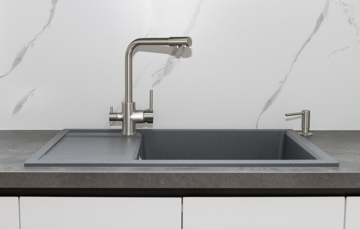 Évier de cuisine gris avec robinet d'eau chromé contre dosseret en marbre Détail intérieur moderne de la cuisine