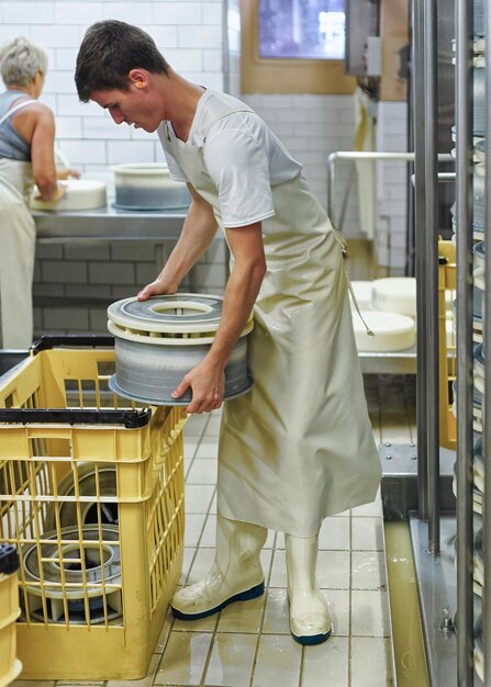 Evillers, France - 31 août 2016 : fromager mettant le fromage Gruyère de Comte dans les formulaires à la laiterie en Franche Comté, Bourgogne, France.