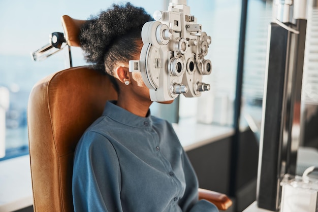 Examen de la vue de test de soins de santé et femme noire dans une clinique d'optométrie pour tester la vue et l'évaluation optique Consultation d'optométriste de vision et patient avec phoropter d'outil médical et lentille pour les yeux