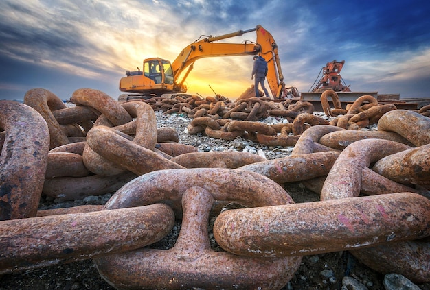 Excavatrice à chaînes devant le ciel de coucher du soleil