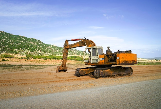 Excavatrice sur un chantier de construction à côté d'une colline