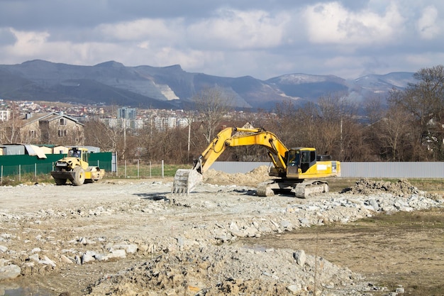 Une excavatrice de construction efface un chantier de construction pour la fondation d'une future maison