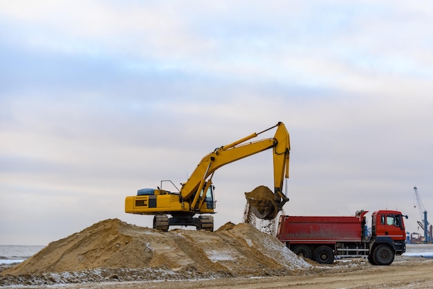 Excavatrice jaune travaillant sur un chantier de construction La construction de la route