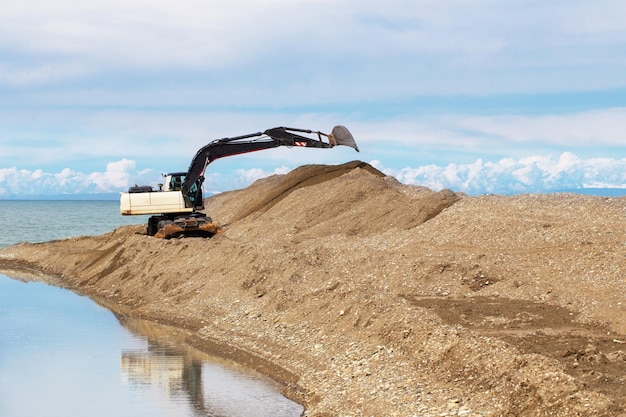 L'excavatrice travaille au bord de la mer