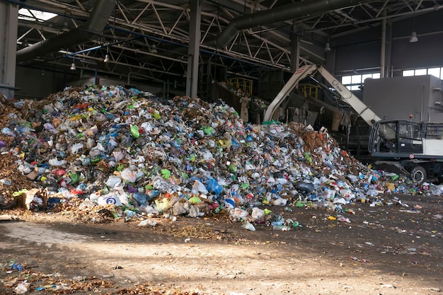 L'excavatrice trie les ordures à l'usine de recyclage des déchets