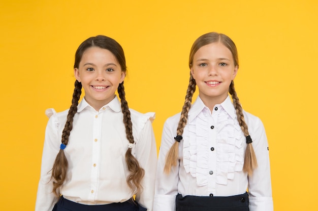 Excellents élèves Tenue uniforme parfaite des filles sur fond jaune Selon les règles de l'école Les camarades de classe rangent les élèves Programme éducatif pour les enfants surdoués Prix des meilleurs élèves Faire tout bien