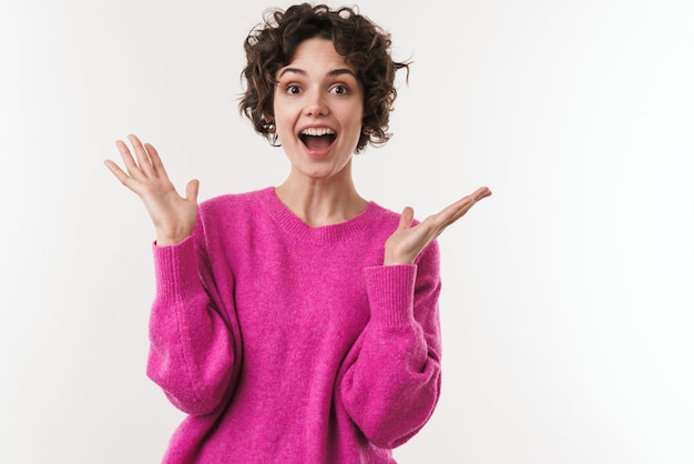 excité belle femme exprimant la surprise à l'avant isolé sur mur blanc