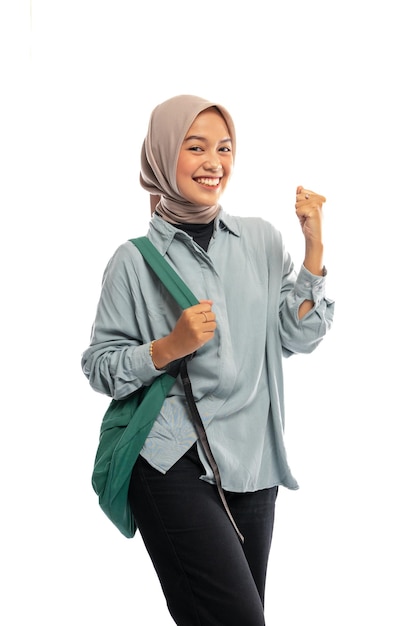 Photo excité étudiant musulman asiatique en hijab célébrer avec sac à dos en arrière-plan isolé
