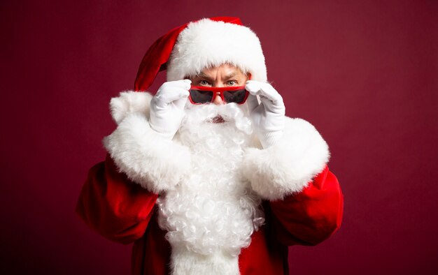 Excité heureux hipster Santa Claus dans des écouteurs et des lunettes de soleil s'amuse à la fête