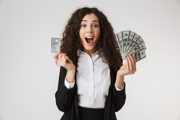 Excité heureux jeune femme d'affaires avec carte de crédit et argent.