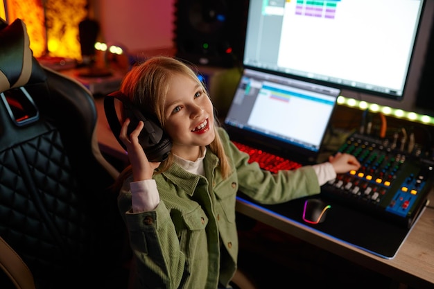 Photo excité jeune fille réussie enfant préadolescent ingénieur du son mélangeant le son à l'intérieur du studio d'enregistrement sonore