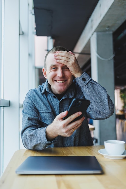 Excité jeune homme en costume utilisant un téléphone portable avec une drôle d'expression homme d'affaires excité regardant son smartphone lisant de bonnes nouvelles par e-mail concept de mode de vie émotionnel