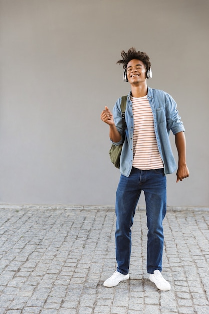 Excité jeune homme avec sac à dos à l'extérieur