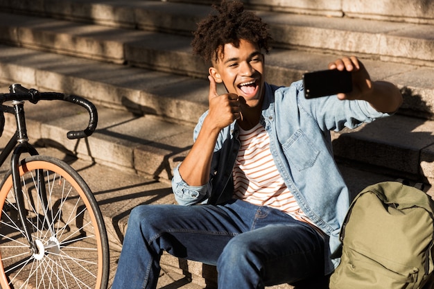 Excité jeune homme avec sac à dos à l'extérieur