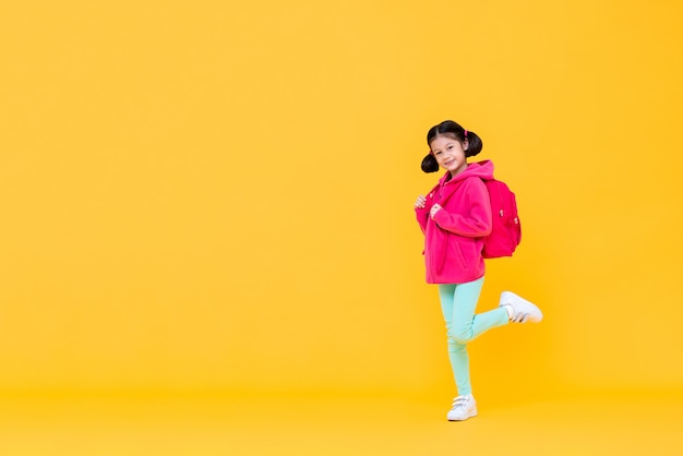 Excité jolie fille aux cheveux en queue de cochon aller à l'école