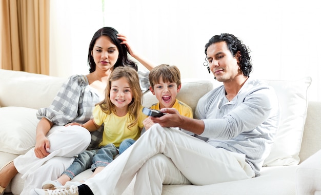 Excité petit garçon regardant la télévision avec sa famille