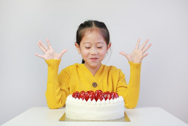 Excité petite fille asiatique avec gâteau aux fraises