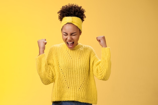 Excité ravi, belle jeune étudiante criant joyeusement, serrer les poings victoire triomphe pose danse célébrant l'acceptation université populaire debout satisfait atteindre l'objectif rêve devenu réalité.