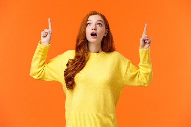 Excité, sans voix et surpris femme rousse étonnée voir la promo de vente