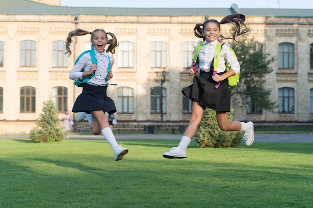 Excited happy girls school uniform jumping concept de bonheur sincère