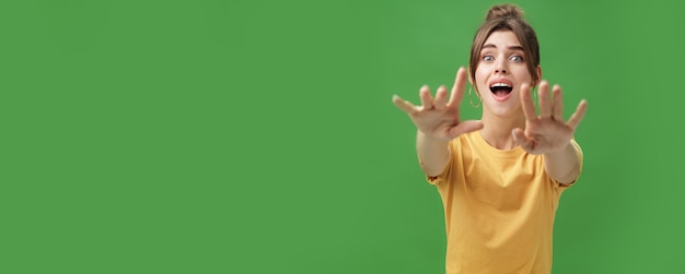 Excitée et accro googlooking jeune femme atteignant les mains vers l'appareil photo avec un regard imprudent blême