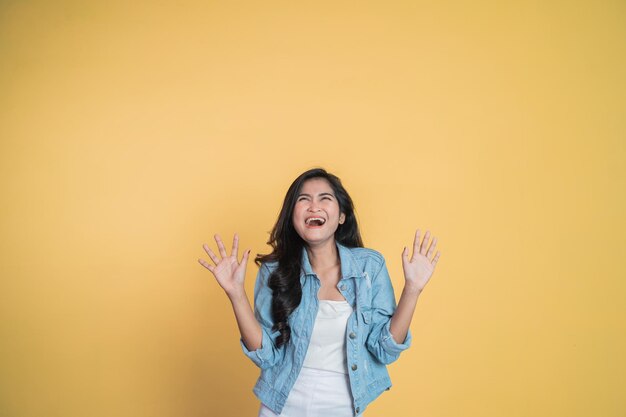 Excitée jeune femme asiatique ouvrant deux paumes en souriant