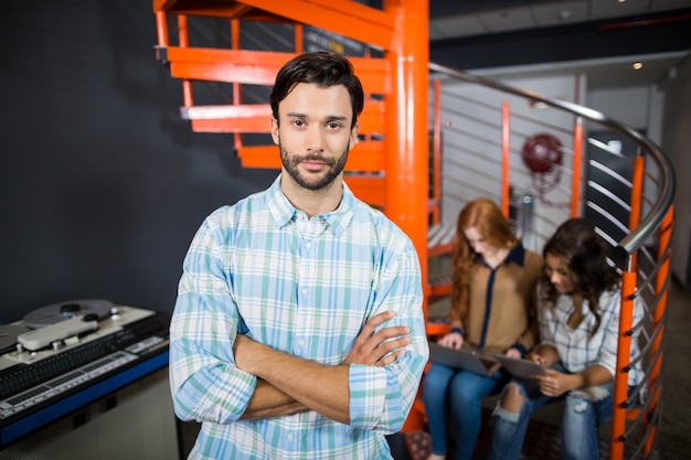 Exécutif masculin debout avec les bras croisés au bureau