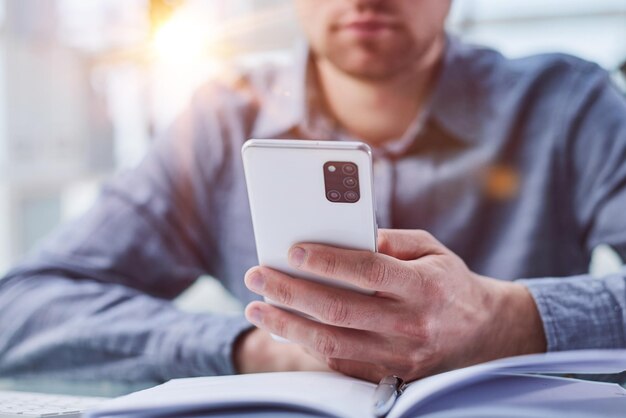 Exécutif professionnel d'homme d'affaires tenant le mobile travaillant au bureau avec le smartphone