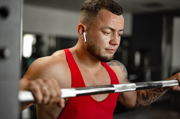 Exercice d'athlète homme fort dans la salle de gym portrait en gros plan