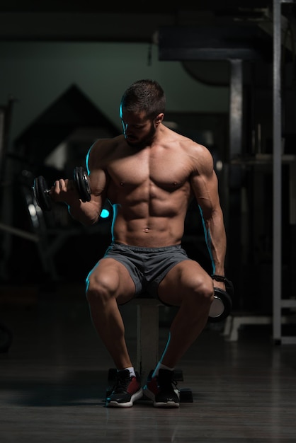 Exercice de biceps avec des haltères dans une salle de sport