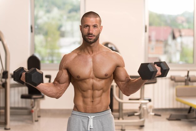 Exercice de biceps avec des haltères dans une salle de sport