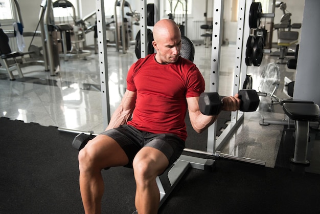 Exercice de biceps avec des haltères dans une salle de sport