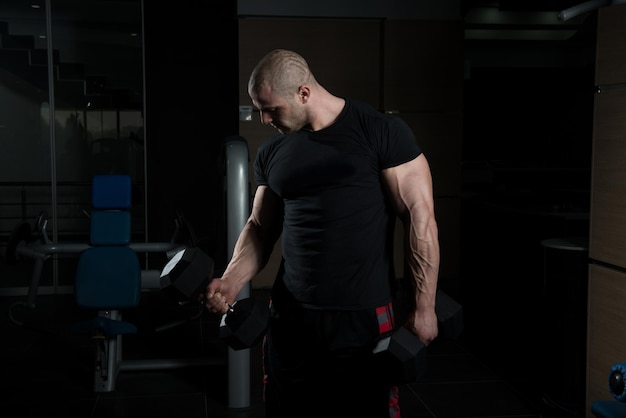 Exercice de biceps avec des haltères dans une salle de sport