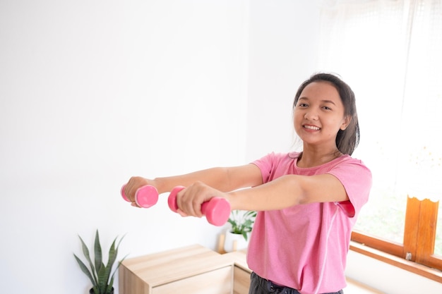 Exercice d'entraînement de jeune fille à la maison dans le salonFille asiatique