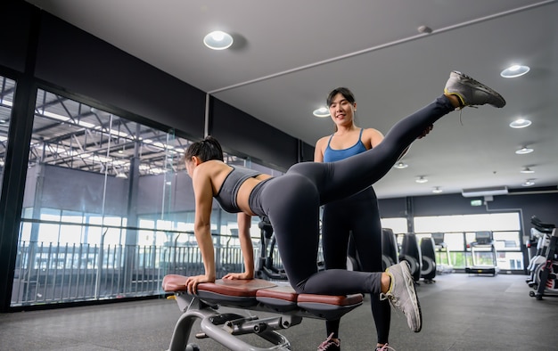 Exercice de femme asiatique et mode de vie à la salle de fitness. Entraînement de femme sportive avec entraîneur. Bien-être et santé pour la musculation.