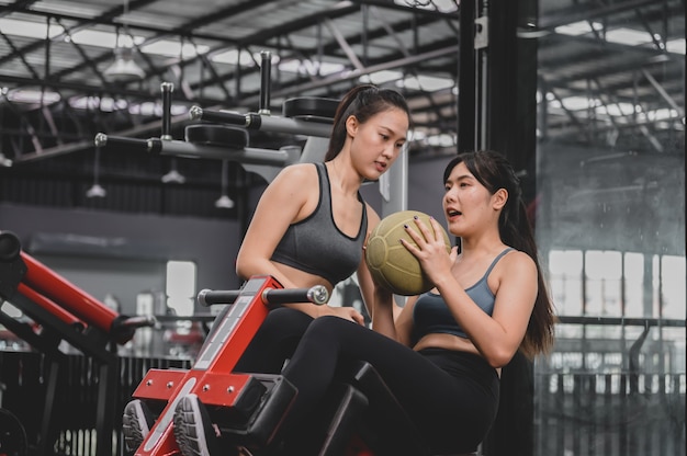 Exercice de femme asiatique et mode de vie à la salle de fitness. Entraînement de femme sportive avec entraîneur. Bien-être et santé pour la musculation.