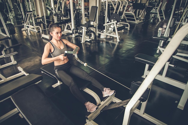 Exercice de femme sexy avec la machine d'exercice dans une salle de sport moderne. Remise en forme de femme dans la salle de gym. Femme asiatique qui prend soin de sa santé en faisant de l'exercice. Soins sains avec concept d'entraînement.