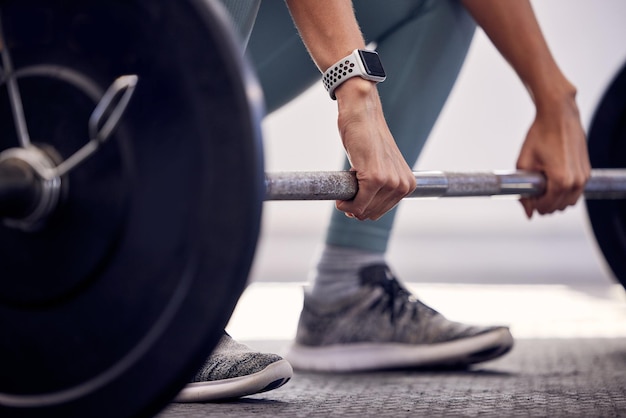 Exercice de fitness et femme forte avec des haltères faisant du soulevé de terre pendant l'entraînement et la musculation pour un corps sain Modèle sportif avec une montre et des poids pour la motivation santé et bien-être