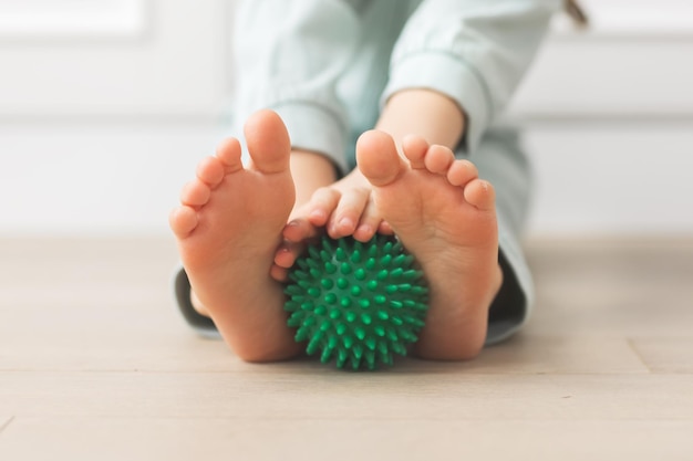 Exercice de physiothérapie avec balle de massage en relief sensations tactiles vert nature couleurs pieds nus