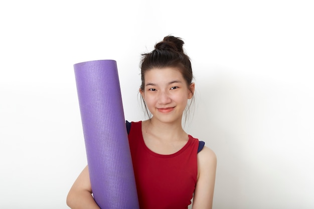 Exercice de remise en forme femme asiatique thaïlandaise prête pour l'entraînement debout tenant un tapis de yoga