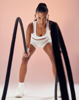 Exercice de remise en forme et femme faisant des exercices de cordes de combat dans sa routine d'entraînement saine dans un studio de sport énergie de fille et athlète en mouvement actif travaillant sur le cardio pour l'action de force musculaire