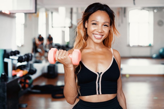 Exercices sur les biceps du corps avec des haltères Un entraîneur fort dans des vêtements confortables